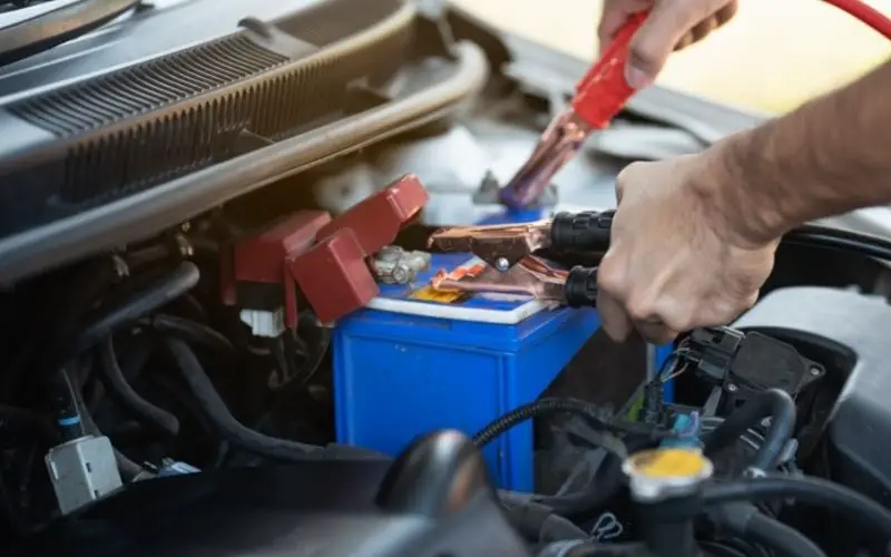 man checking car battery and repairing car